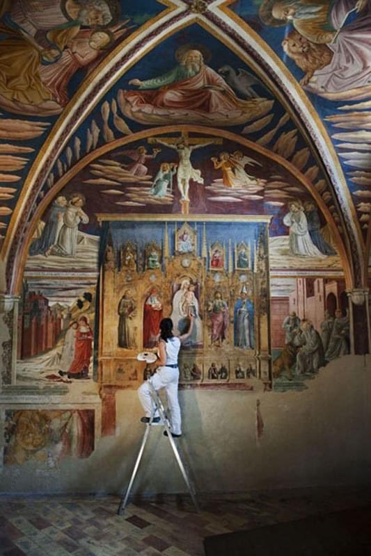 Una restauratrice all'opera nella chiesa di San Francesco a Montefalco. 📸Steve McCurry