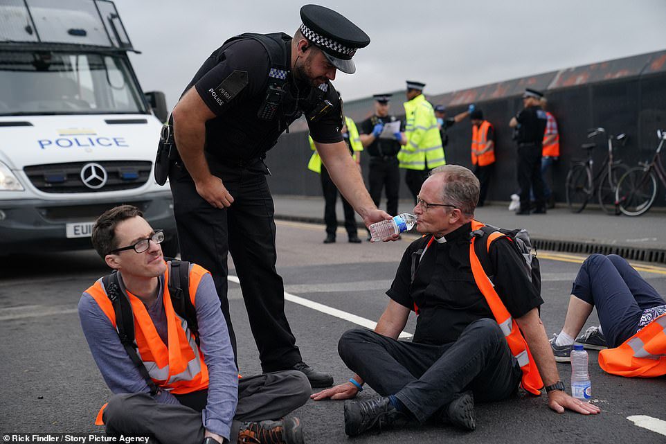 ArchRose90's tweet photo. The police officer should be forcefully removing him instead of making him comfortable. 

It’s no wonder people are losing respect for them. https://t.co/QFtYpwEoRY