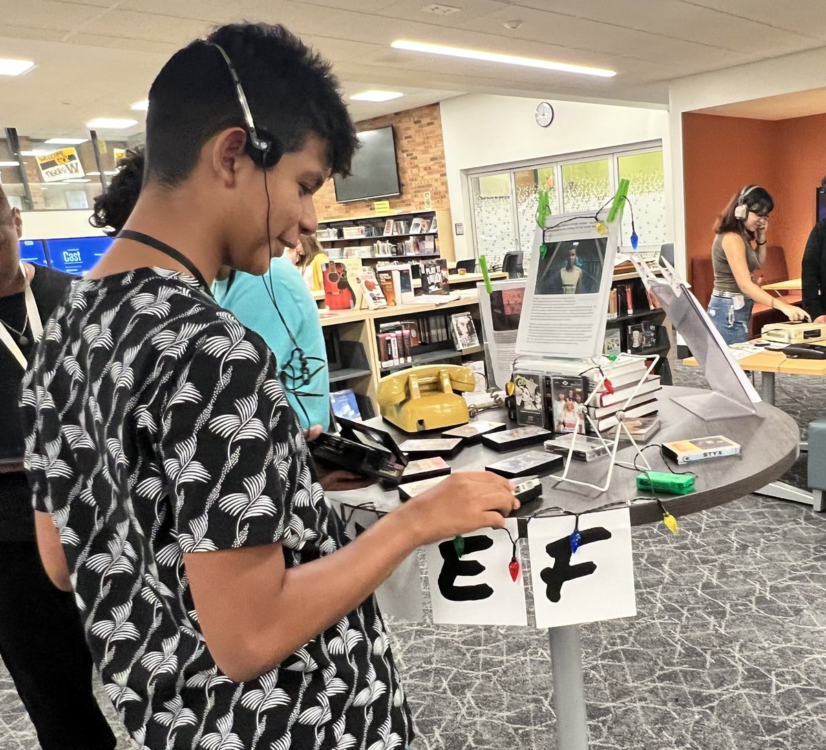 JTWestLibrary's tweet photo. Welcome to your Library Joliet West Freshmen!  Library Orientations this week have us reading, coloring bookmarks, looking up family members in old @JWHSmedia yearbooks, &amp; listening to cassettes on a Walkman at our Stranger Things display. The #Classof2026 rocks! https://t.co/woImWcHU75