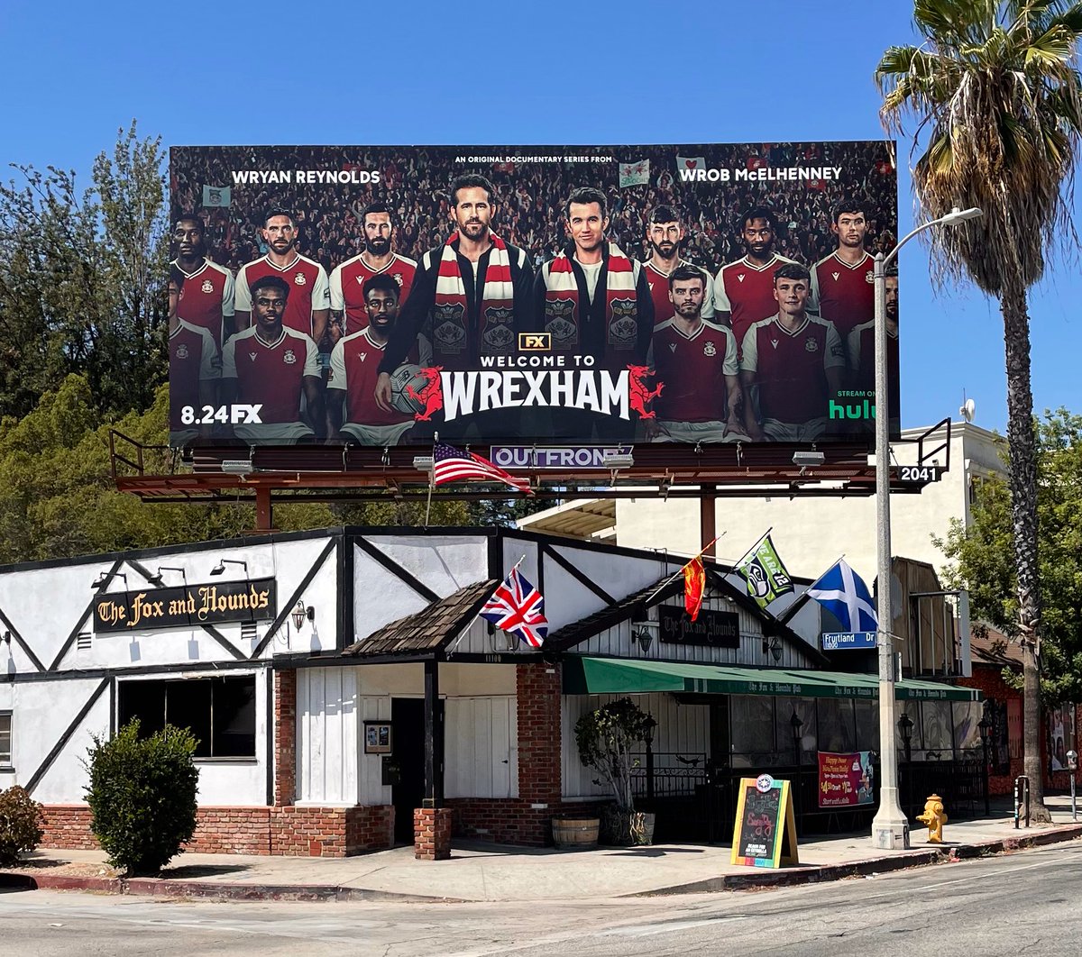 BobKronbauer's tweet photo. It’s Wryan @VancityReynolds on the roof of The Fox and Hounds British pub in Century City! A shrewd location choice for a billboard promoting a show about he and his friend saving an English soccer team. 🙌🏻 #WelcometoWrexham https://t.co/Mc9N2fKQWG