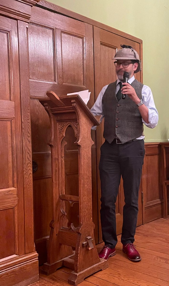 TraversOxf's tweet photo. The plausible @radiomukhers captured so well by @Shotsblog - stayed in character for a terrific @HildasCrime Whodunnit ‘Murder in Green’ by @PhilipGooden - from the pipe &amp; hat to the Zoom background for online attendees, a performance as highly polished as his brogues! Bravo https://t.co/yE3dt1aoFI