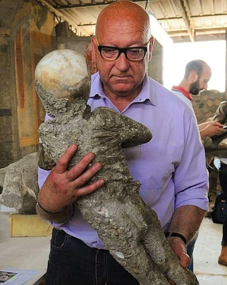 JamesLucasIT's tweet photo. Un archeologo che tiene in braccio il corpo in gesso di un bambino di 4 anni ucciso dall'eruzione del Vesuvio a Pompei nel 79 d.C. https://t.co/E8Uu6TYgON