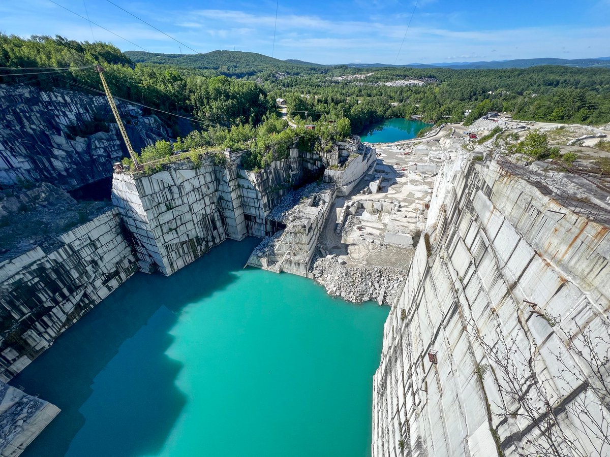 VermontTourism's tweet photo. Vermont is home to the world's largest deep-hole granite quarry. Rock of Ages offers tours where visitors can stand 200 feet above the quarry, observe stone carvers crafting headstones, and bowl on the quarry's granite lane. Via @washingtonpost: https://t.co/ocVXWIyUS1 #ThisIsVT https://t.co/DFgqr5Bhwn