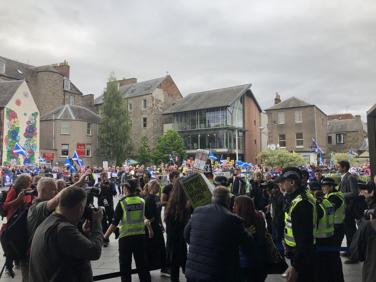 Oh some of the protestors have broken through the ring of steel; they’re now standing outside the hastily closed doors chanting “Tory scum”