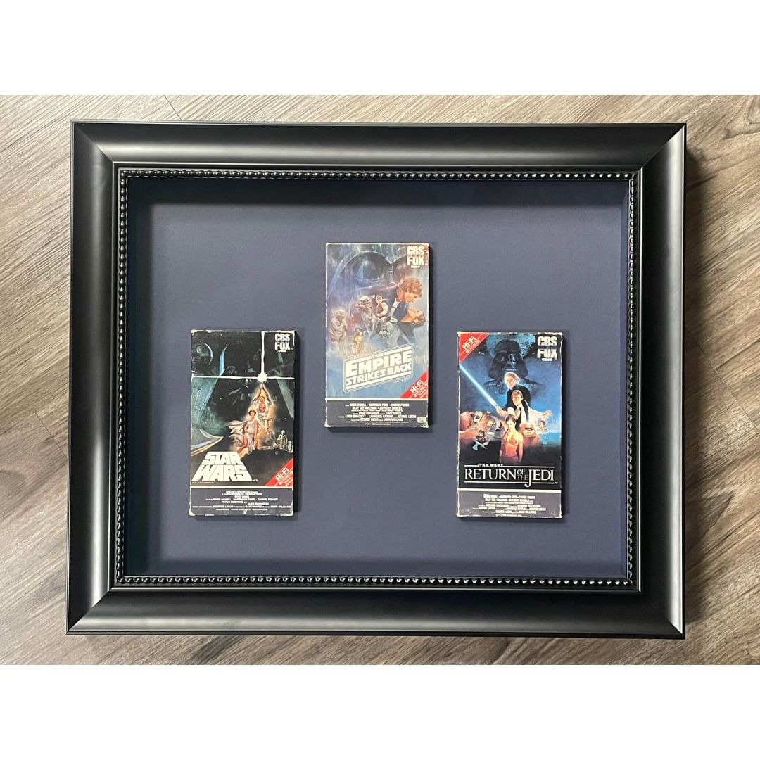 "A couple brought in VHS boxes from the original #StarWars trilogy. We built a #shadowbox by stacking two frames and opened up the back so they can read the backs and added #MuseumGlass so they could view these without seeing their reflection." –#ThisAndThatFraming 