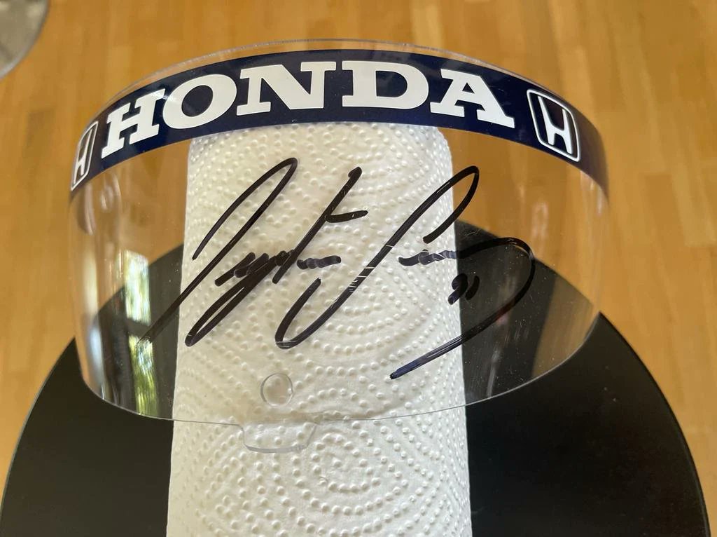 1991 Ayrton Senna race used Rheos visor hand signed
used by Ayrton while driving the MP4/6. 

Ayrton Senna's pieces are incredibly difficult to acquire due to their extreme rarity. The 1991 Senna Rheos is one of the most iconic and sought after helmets.
Price: US$8,900