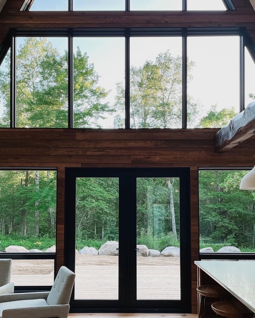 Gorgeous wood interiors are highlighted with modern walls of windows. Thanks for sharing this cabin getaway, @northwoodsaframe and @pella_northland. #PellaInspired