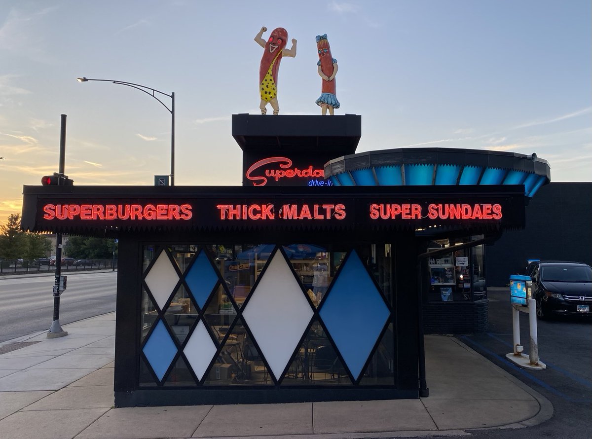 BlairKamin's tweet photo. What a neon-lit pleasure to be at Superdawg and I haven’t even eaten yet! From the iconic Maurie and Flaurie hot dog sculptures to the blue, O’Hare control tower-inspired “pavilion” out back to the exuberant diamonds (inspired by 50s garage doors), the place rocks architecturally https://t.co/Xhe29SsdQW