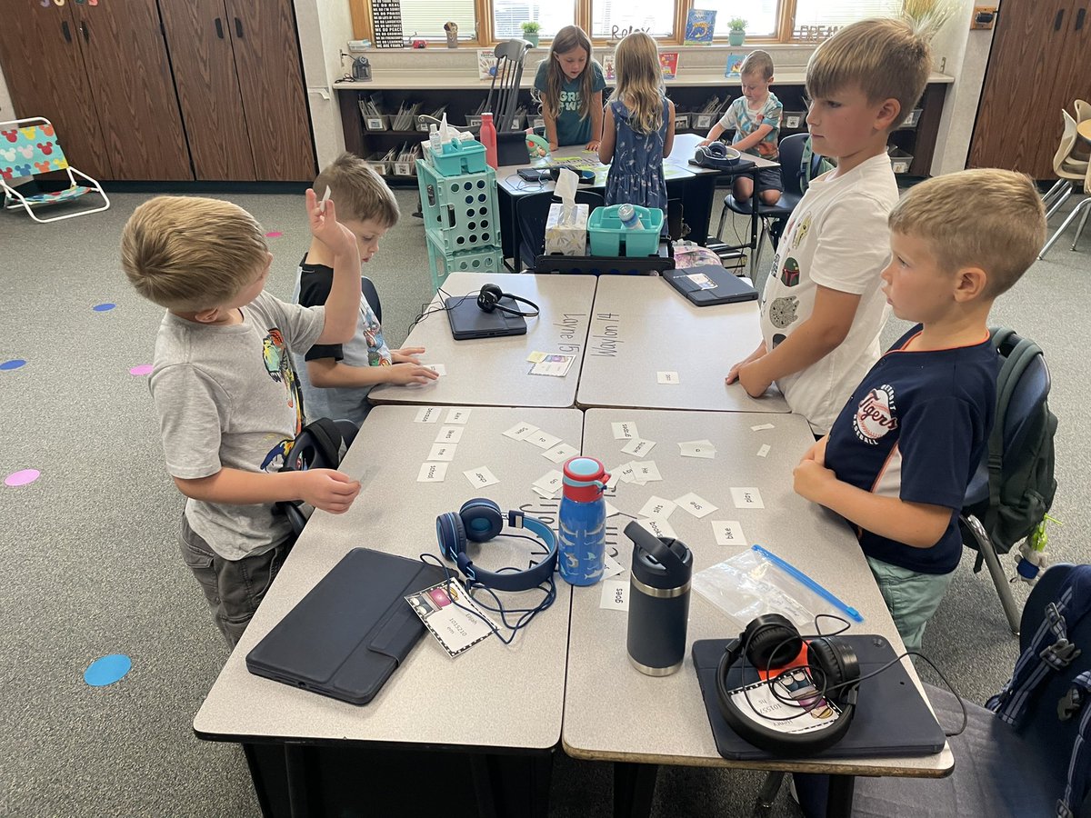 Students putting words together to make a sentence. One friend says: “Hey-we have to show it stops!”