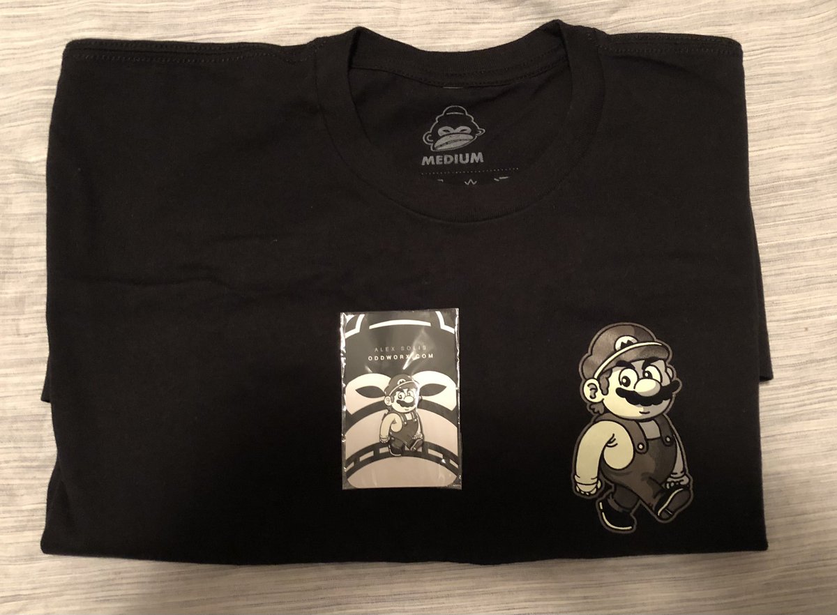 TheMrCan's tweet photo. Just realized that I have a t-shirt that matches the famous Mario viral pin created by @alexmdc7 that I purchased with #oddx from staking my @GenzeeNFTs. https://t.co/x0Y1SwDLID