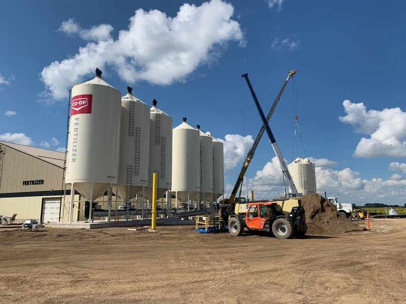 homestead_coop's tweet photo. Going vertical! Work continues on our Austin Agro site! Yesterday we had 8 @meridianmfg bins placed with 2 crane operators onsite, along with the @HiTechInstall crew. We're on track to be finished by early October. #WstCdnAg #ManitobaAg #CanadianAgriculture #Manitoba #MBFarming https://t.co/eOGbX8odax