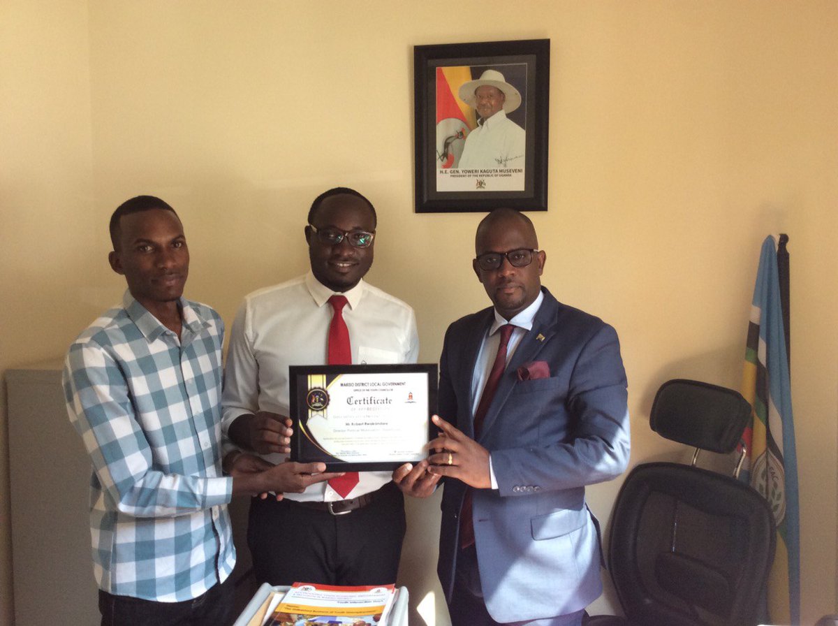 Director Statehouse political mobilisation Robert Rwakandare with  Kenneth Matsiko Nuwe (Secretary to Wakiso Youth Council) and Project coordinator, Wakiso Youth Interaction Days and Mr. Ibrahim Kazibwe, Wakiso District Youth Councillor, handing over a certificate of appreciation