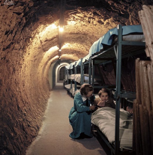HistoryInPics's tweet photo. Woman kneeling next to bed of child, in an underground tunnel during the bombing of London, World War II, January 1945 https://t.co/jio2kPnVgP