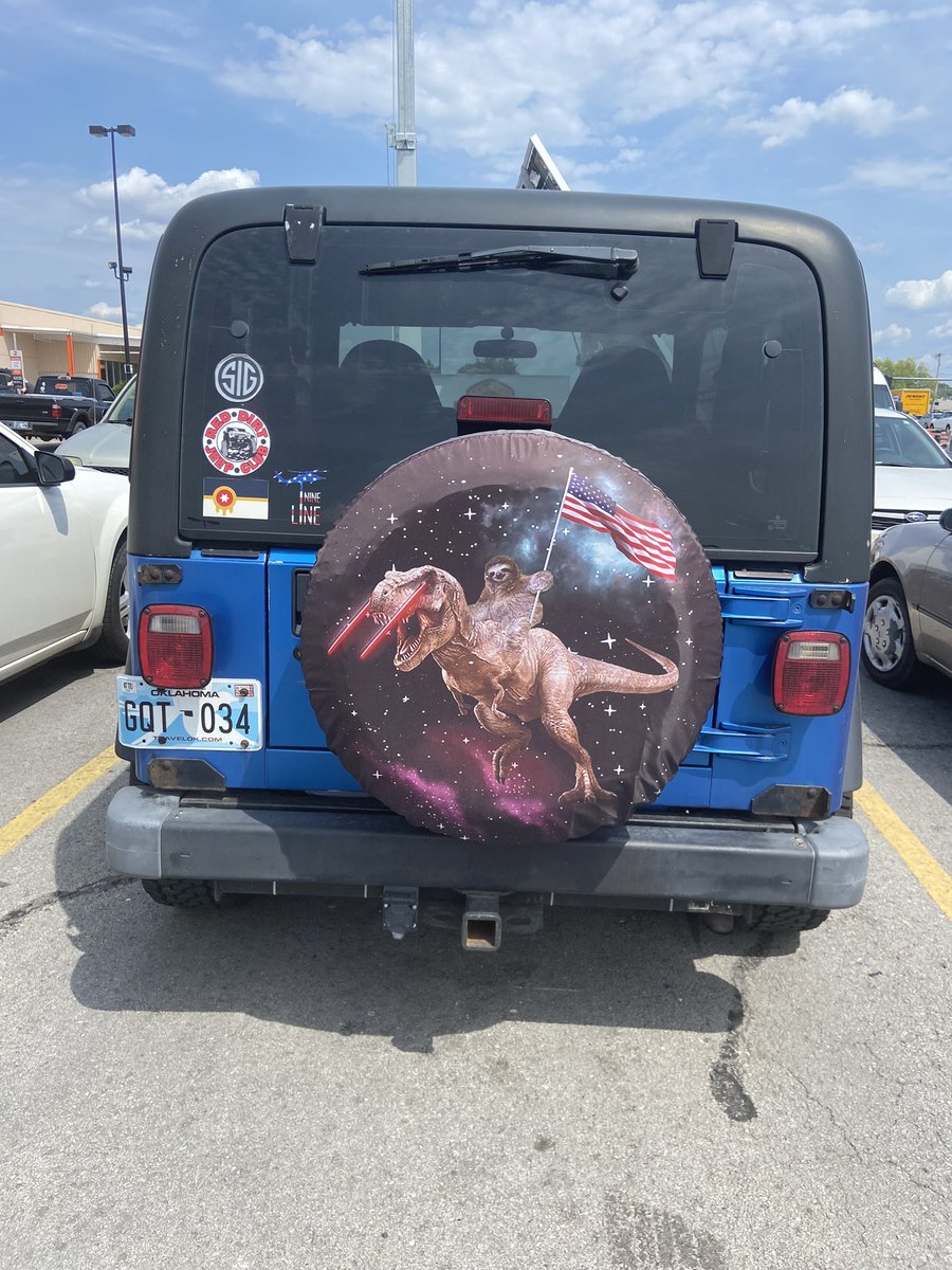 kabiggidy's tweet photo. Saw this Jeep tire cover at Home Depot over the weekend.  Sloth holding an American Flag riding a T-Rex with laser beam eyes…….in space. Well done my friend. Well done. https://t.co/38g1qzBDXP