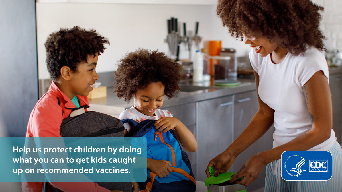 Smiling mother making lunch for her two children with a text overlay that reads, “Help us protect children by doing what you can to get kids caught up on recommended vaccines.”