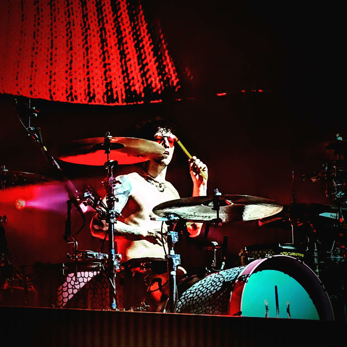 EllieRosecroft's tweet photo. Here we see @joshuadun slaying it at the #icyphilly show on the #icytour...photo 1 smiling, photo 2 having fun, photo 3 intercepting a transmission? Then in full SpookyJimChristmas mode starts calling to the mothership via his drumsticks. It was wild, man. @twentyonepilots https://t.co/ycF3ju3xOD