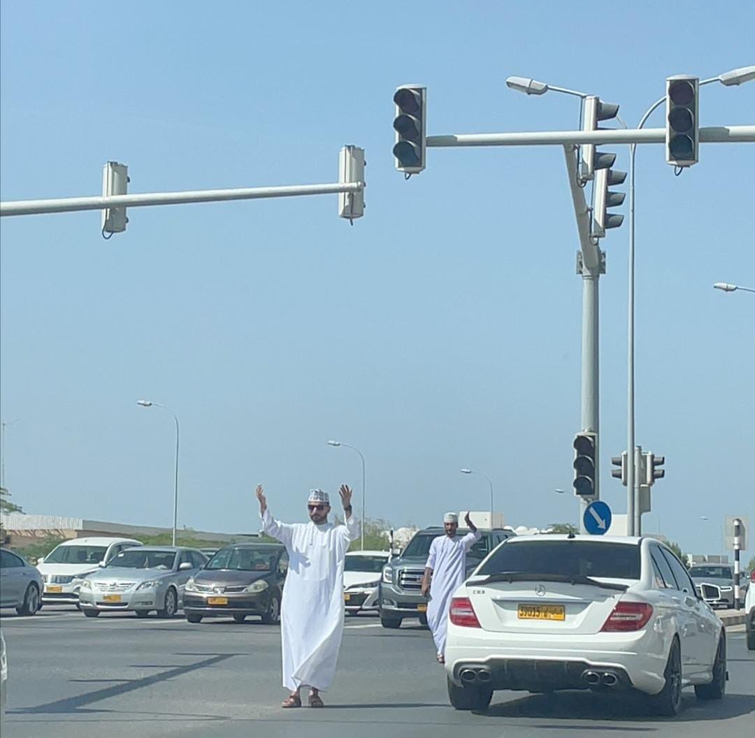 مُواطنان وهما يُنظِّمان حركة السّير بعْد توقف الاشارات المرورية بسبب #انقطاع_الكهرباء