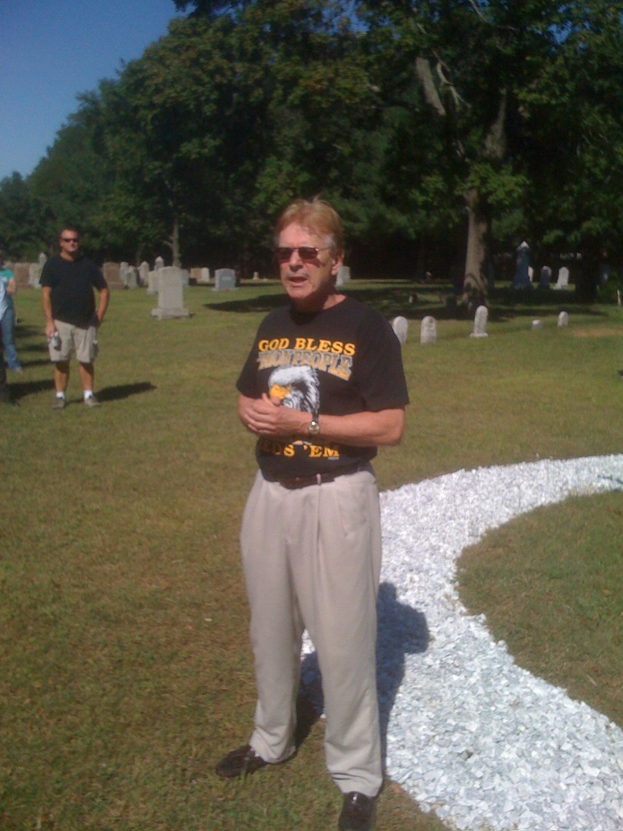 Bullet holes in tombstones bear witness to the 1934 Saylesville massacre in Central Falls. Scott Molloy is shown discussing that during a past Labor Day event