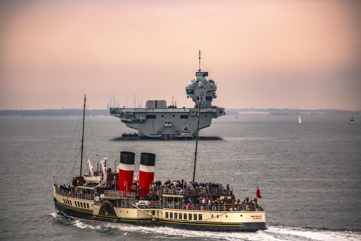 The oldest working seagoing paddle steamer in the world, PS Waverley, passes by the newest, not working, warship, HMS Prince of Wales, off the Isle of Wight yesterday. [Photo by Chris Glover from Isle of Wight County Press]