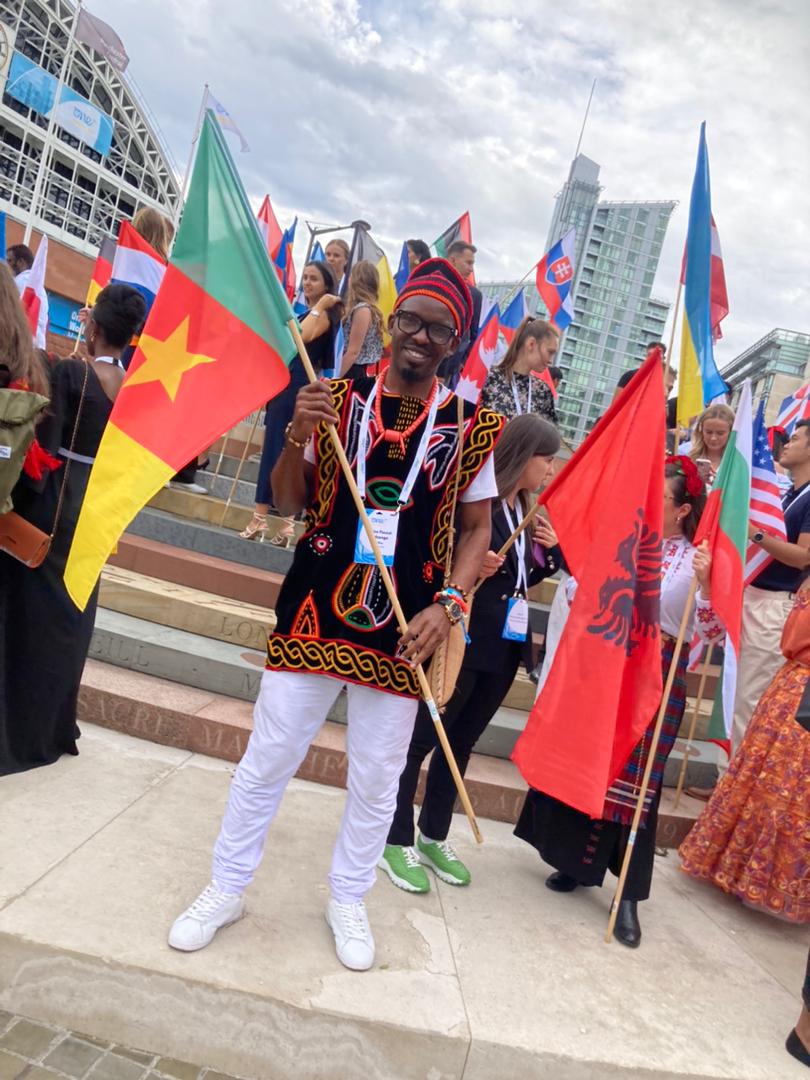 EdukMedia's tweet photo. Cameroon honored in Manchester. @AndzongoBlaise with the Cameroon flag and traditional dress at the @OneYoungWorld summit in #Manchester
#OYW2022 https://t.co/gB9dPGx80l
