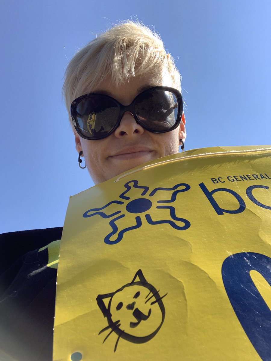 Cee3Nellie's tweet photo. We want COLA! On the picket line today with Liquor Distribution Branch workers in Victoria. Hand drawn @JortsTheCat merch on my sign. #bcgeu #FightForCola #SharpClawsSoftPaws https://t.co/b5keNZxvgL