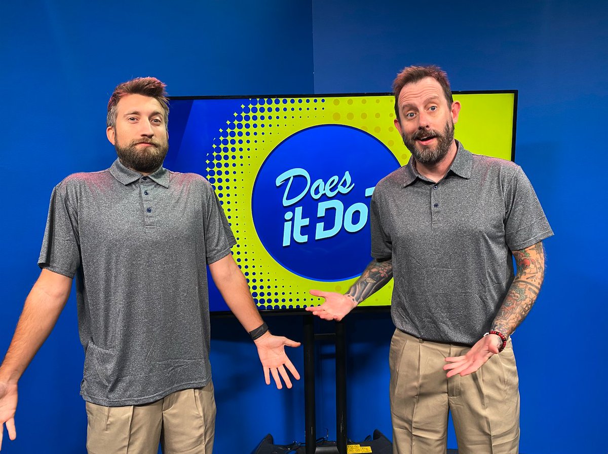 Geoff and Gavin in a blue room, wearing matching gray collared short-sleeved shirts and tan-colored pants. Gavin's shirt is noticably a few sizes too large. Behind them is a television on a stand, displaying the "Does it Do?" logo on its screen. Said logo has both cursive and non-cursive fonts in white in front of a blue circle, which is in front of a yellow and blue background that has halftones on it.