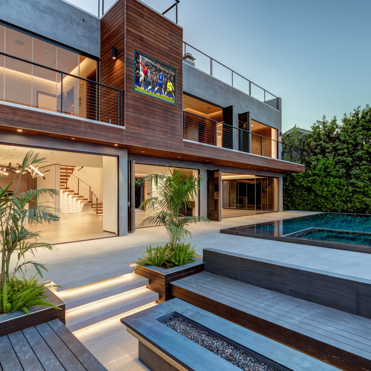 What you see: 
- A super trendy backyard

What we see: 
- integrated patio lights
- indoor/outdoor space
- pool lighting
- soffit lighting 
- outdoor, mounted television 
- outdoor sound
- retractable doors 

There's a lot that goes into creating what you see.