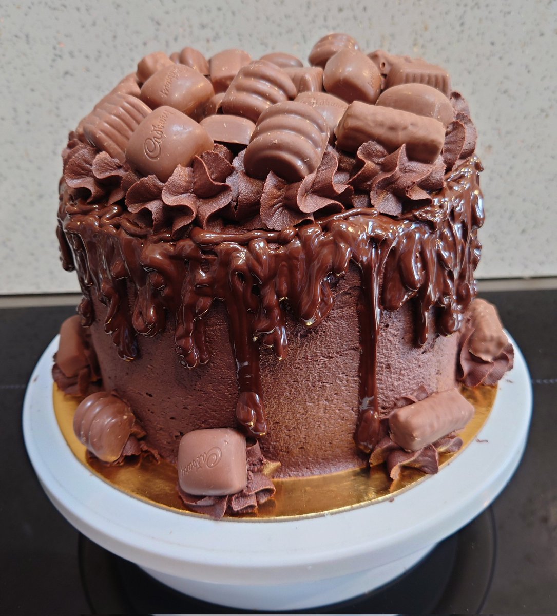CuppyCC's tweet photo. Triple layer chocolate cake with chocolate drizzle and Cadbury Heroes chocolates. #CuppyCC #chocolatecake #Yum https://t.co/Kad22SZKvX