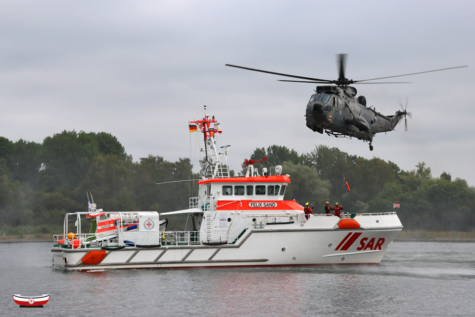 Seenotretter's tweet photo. Besondere #Seenotretter-Momente 🤩 vor einmaliger Kulisse: Tolle Aufnahmen vom gestern nachgeholten #TagderSeenotretter der #DGzRS-Station #Lübeck-#Travemünde mit #Marineflieger-#WinchEx 🤝 #SARfamily @CdrDeuNavalAir 📸 Dirk Wiggers – Fotos bundesweit: ➡️ https://t.co/w1v4ssFNJq https://t.co/rWU1OyGztV