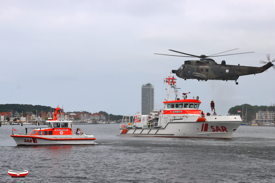 Seenotretter's tweet photo. Besondere #Seenotretter-Momente 🤩 vor einmaliger Kulisse: Tolle Aufnahmen vom gestern nachgeholten #TagderSeenotretter der #DGzRS-Station #Lübeck-#Travemünde mit #Marineflieger-#WinchEx 🤝 #SARfamily @CdrDeuNavalAir 📸 Dirk Wiggers – Fotos bundesweit: ➡️ https://t.co/w1v4ssFNJq https://t.co/rWU1OyGztV