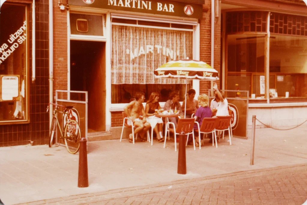 DeBoschloog's tweet photo. Even een terrasje pakken op een warme dorstige dag. In 1975 deden ze dat niet anders. Bijvoorbeeld hier in de Martini Bar in de Hinthamerstraat in Den Bosch. Inclusief een functioneel parasolletje :) Tegenwoordig vind je hier het gezellige café De Palm. (Foto Erfgoed DB) https://t.co/k3xpuXVtuT