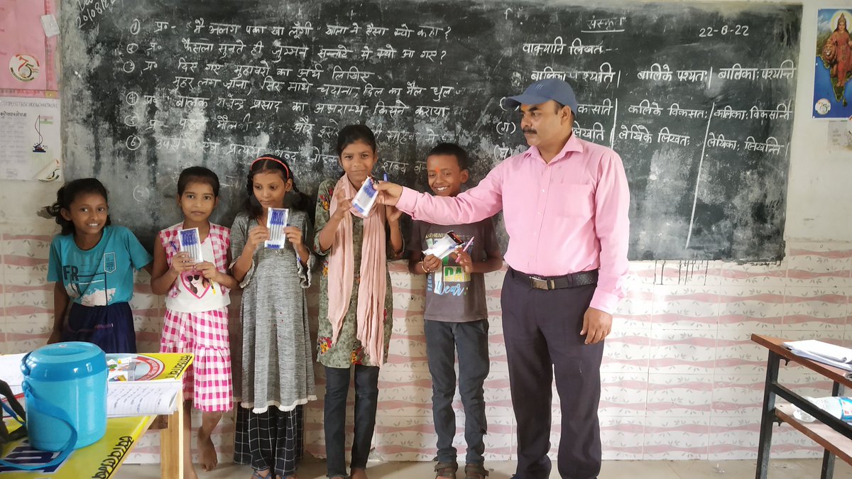 बच्चों को पुरस्कार स्वरूप लेखनी भेंट करते हुए