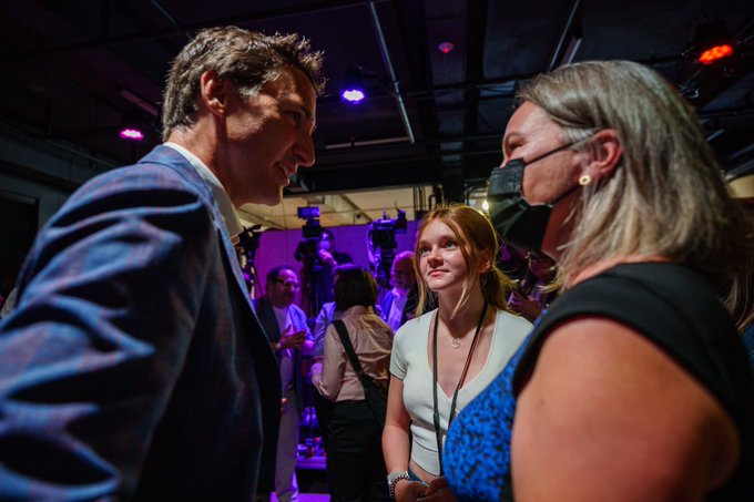 Prime Minister Justin Trudeau is standing and speaking with people inside.