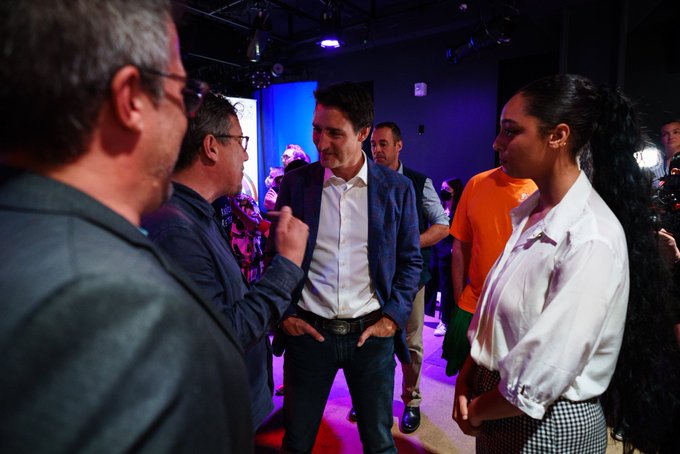 Prime Minister Justin Trudeau is standing and speaking with people inside.