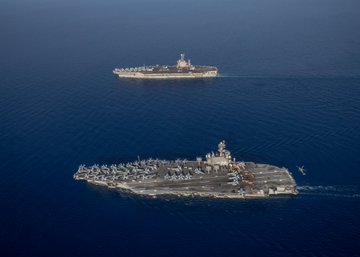 The Nimitz-class aircraft carrier USS George H.W. Bush (CVN 77), bottom, operates with the Nimitz-class aircraft carrier USS Harry S. Truman (CVN 75), Aug. 27, 2022. The George H.W. Bush Carrier Strike Group (GHWBCSG) is on a scheduled deployment in the U.S. Naval Forces Europe area of operations, employed by U.S. Sixth Fleet to defend U.S., allied and partner interests. (U.S. Navy photo by Mass Communication Specialist Seaman Samuel Wagner)