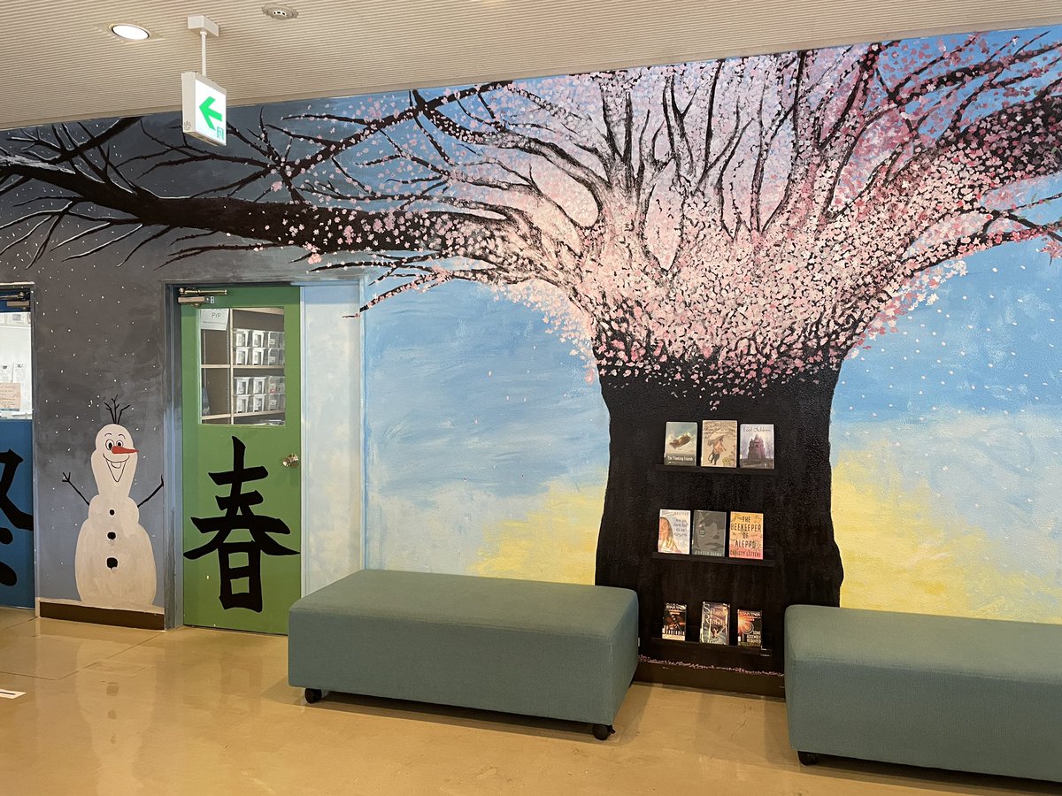 LibraryKirkL's tweet photo. Perfect day for #reading under a tree. Loving our new student produced mural. @sakuramedal #FISlearns #FISreads #sakura. @FISSharks #intlchat https://t.co/u9goVyJCZx