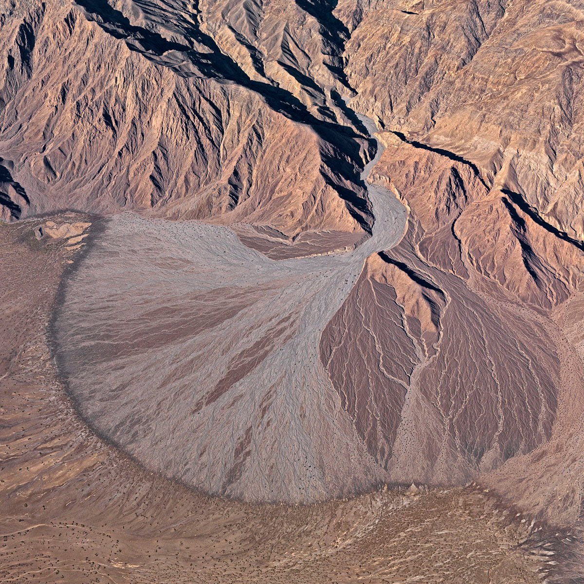 Un abanico aluvial es un depósito de sedimentos que se crea cuando la pendiente de una corriente fluvial disminuye abruptamente, como por ejemplo entre una cordillera y una llanura #geology #geología Death Valley, #California (#USA) 📷Bernhard Edmaier