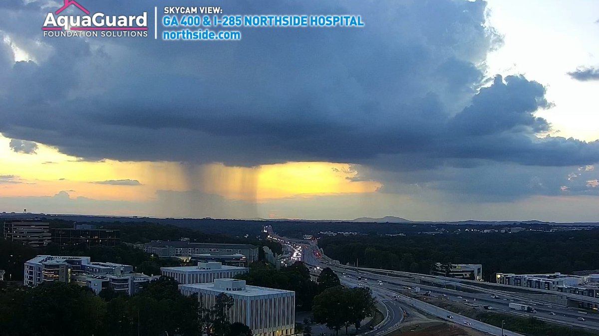 ChrisHolcomb's tweet photo. Cool view of an isolated shower between Smyrna and Sandy Springs as the sun sets behind it. View from our Northside Hospital tower cam. #Storm1 https://t.co/zLe2HGqeiO