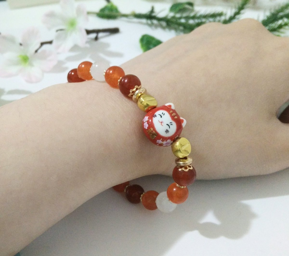 RabbiteersCo's tweet photo. A daruma cat bracelet! I wonder if I'll get any good fortune in the future... 🤔 https://t.co/llFc2T3mHK