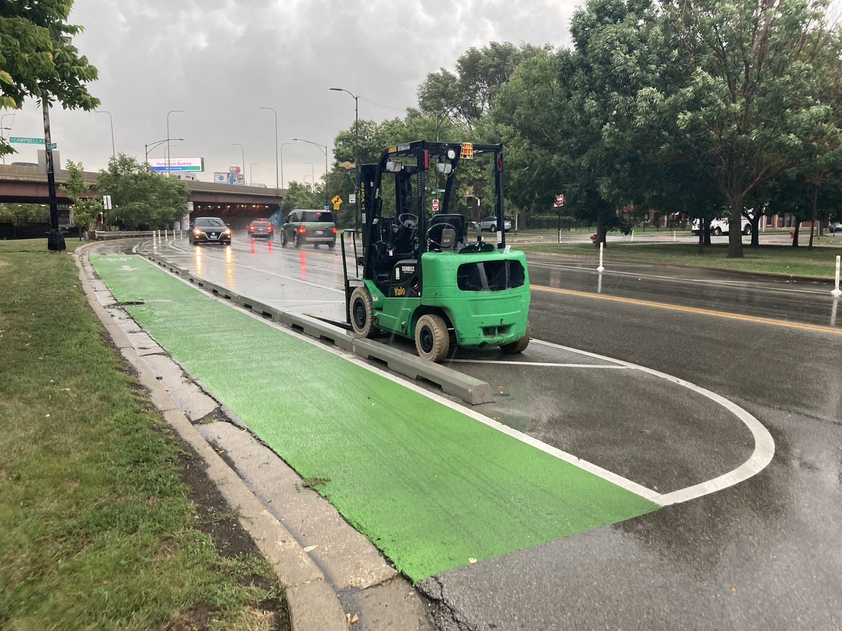 ChicagoDOT's tweet photo. A little rain couldn’t stop new pre-cast concrete curbs from being installed along the Logan Blvd bike lane! Work began yesterday between Rockwell and Diversey and will continue throughout the week. #ChicagoWorks https://t.co/XwBxLUoR9A