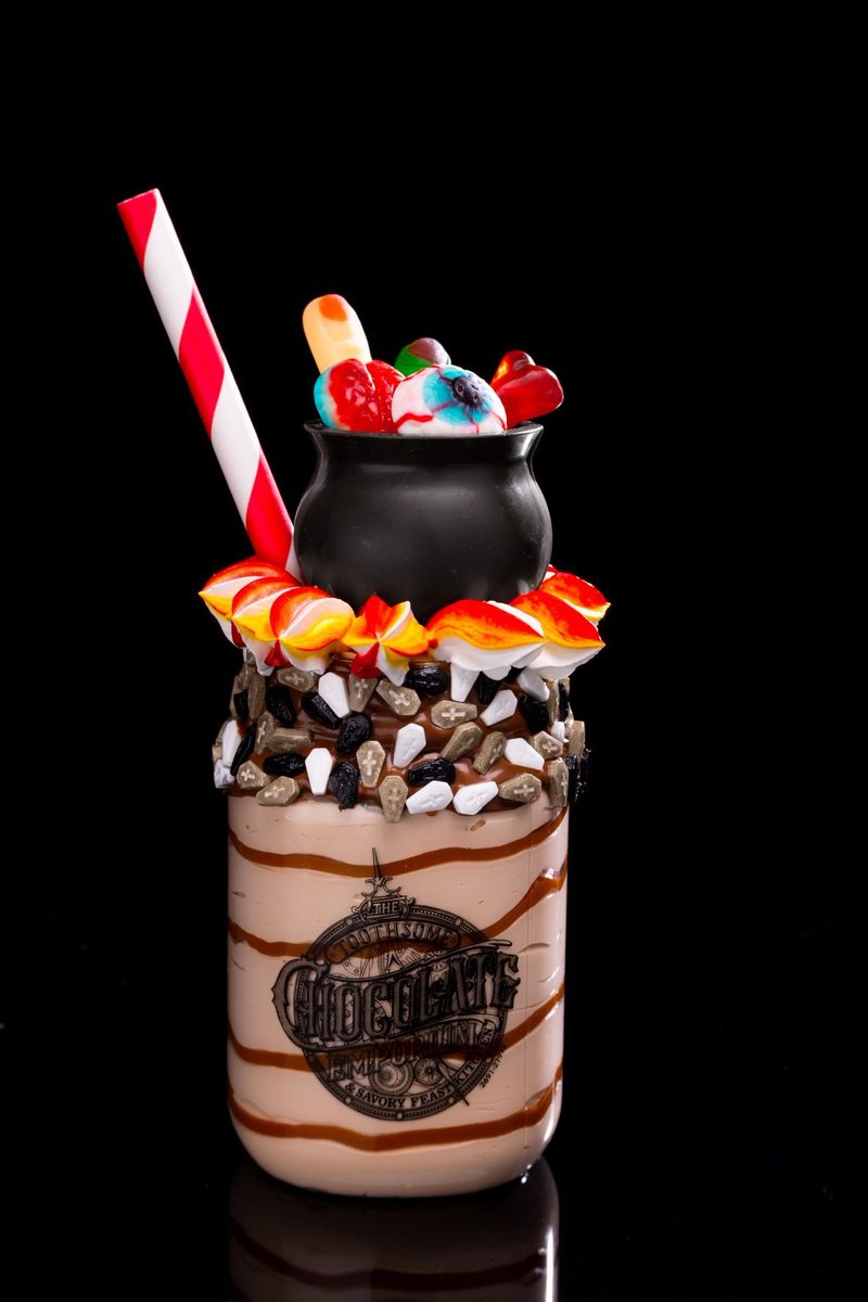 insideuniversal's tweet image. For the Horror season, the new Black Magic Milkshake will be featured at Toothsome - featuring pumpkin dulce de leche ice cream with a hazelnut-and-tombstone-sprinkled rim; topped with a cauldron filled with gummy “severed body parts” over whipped “flames”. #HHN31