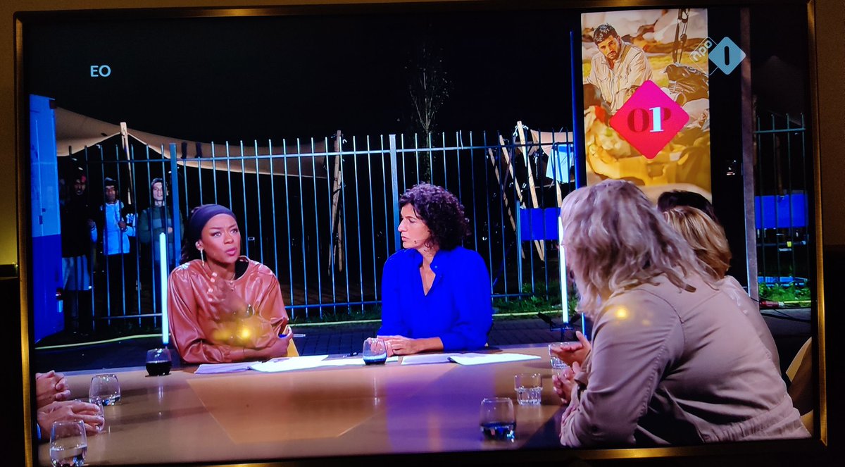 Ammer_B's tweet photo. Fascinating shocking display in the Netherlands where they the housing crisis for refugees escalated. The talkshow @op1npo now folded overboard all ethical standard and installed the talkshow table in front of the crisis shelter. No refugees at the table. They can watch. https://t.co/GP9DUgNVVn