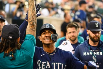 Julio Rodríguez celebrates in the dugout. 