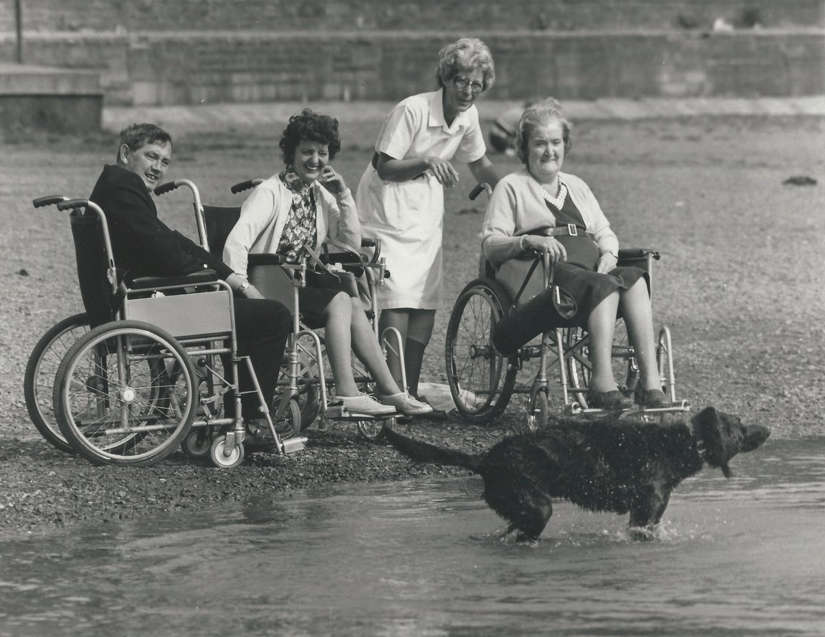 A group of people at the beach watching a dog playing in the water.
Photograph taken by Norman Potter around 1985.
#ExploreYourArchive #EYAAnimals #WaybackWednesday