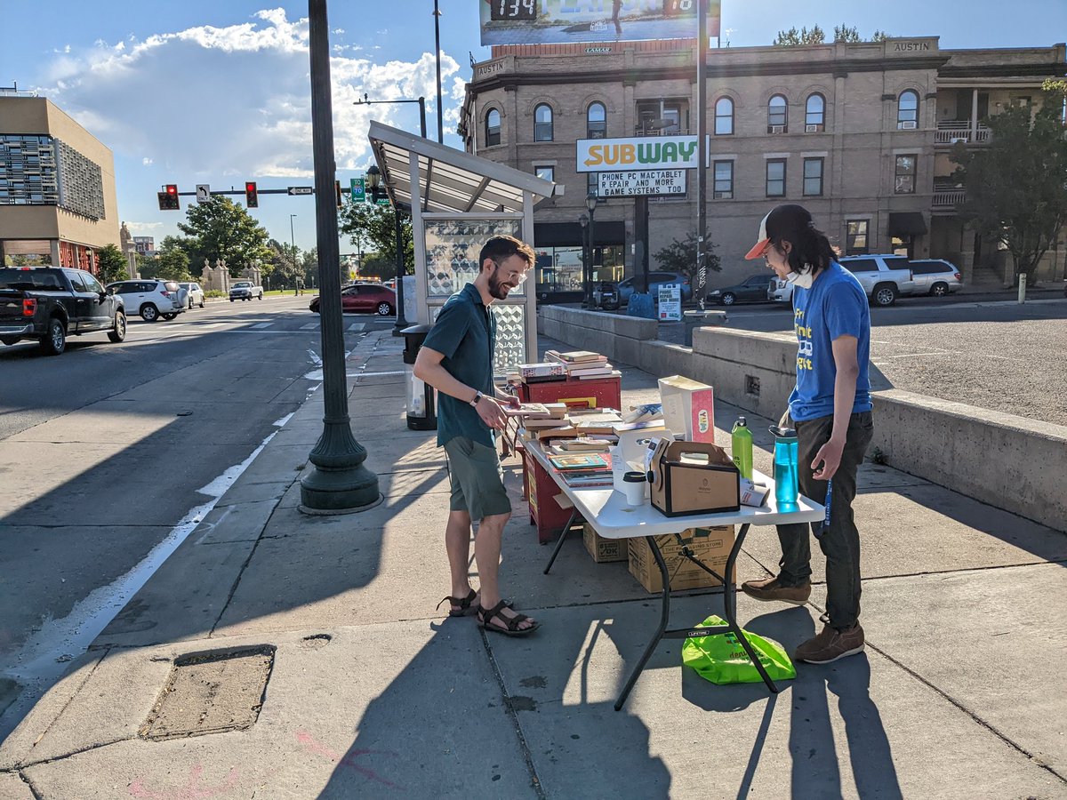 JakeBikesDenver's tweet photo. Bus stops need more books and donuts! Great idea from transit champ @aumi9292 - @marxling also out here helping out! https://t.co/gc0XtPO2ki