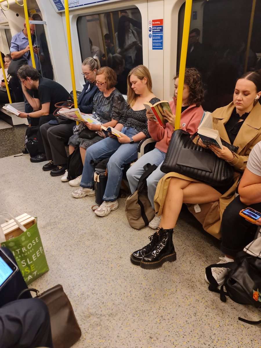 On the morning rush hour tube right now and look at this; a whole row of people reading books. It's a sad state of affairs when people can't afford mobile phones and have to resort to books.