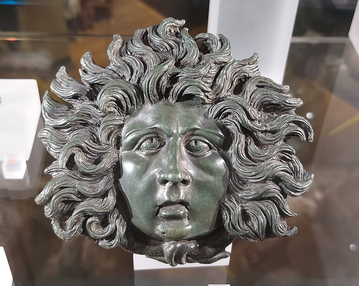 DrNWillburger's tweet photo. A stunning head of Medusa, the mythical creature whose sight turns everyone to stone. Medusa’s head was a popular motif used to ward off any evil. 
The #Roman bronze fitting was found in Xanten, dating 1st century AD

On display at Römermuseum Xanten.

#RomanArchaeology https://t.co/dqksj0xNtN