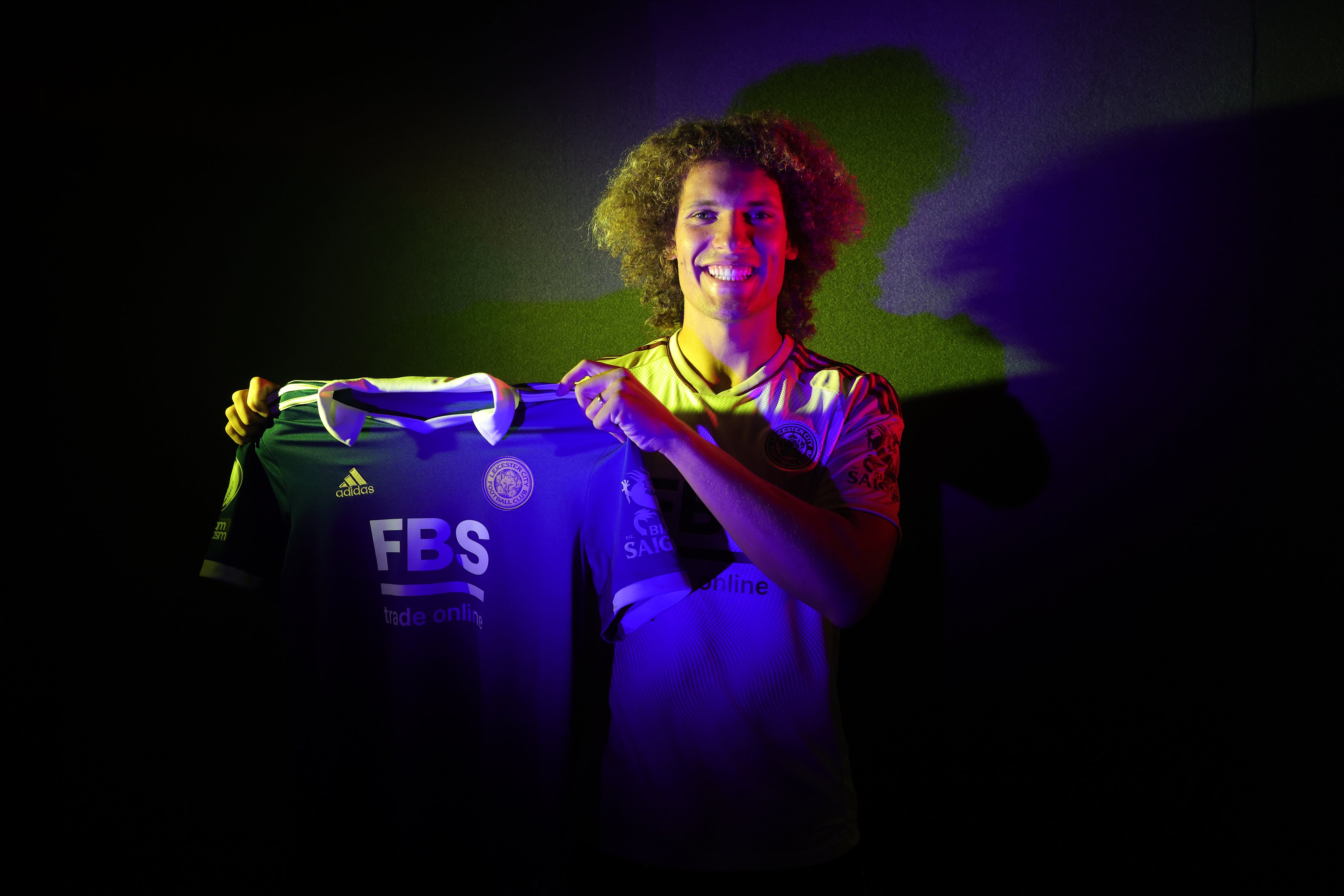 Wout Faes holds up a home Leicester City shirt.