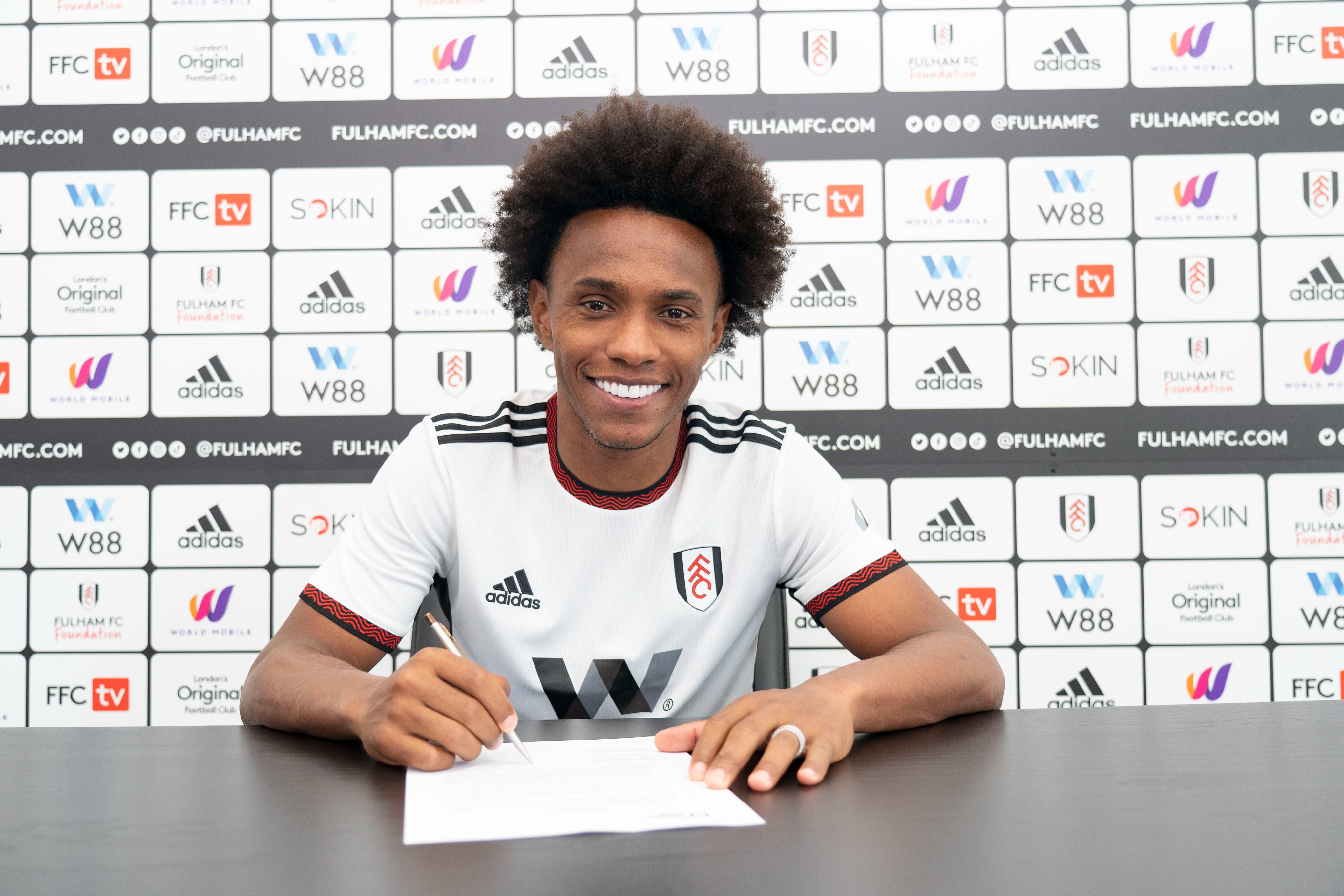 Willian signs his Fulham contract.