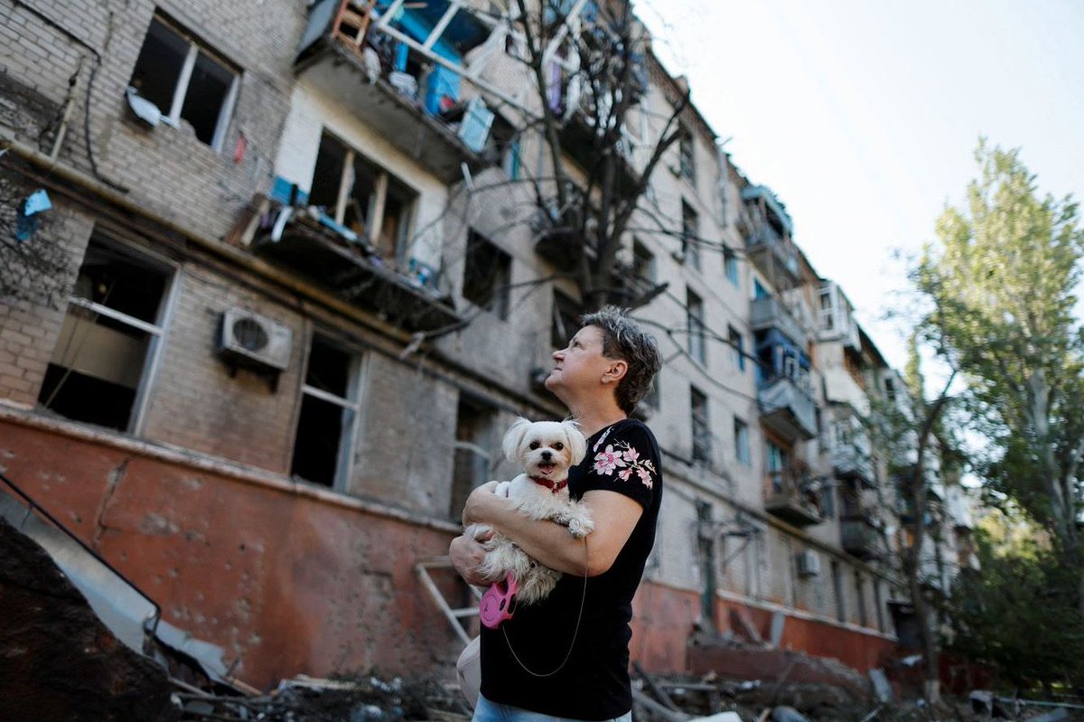 zav_raya's tweet photo. A resident of Kramatorsk, Donetsk region, with a dog in her arms, looks at a house damaged by a missile strike. #Ukraine️ #war #RussianAggression #RussianWarCrimes #RussiaIsATerroristState https://t.co/i8vO9lRfHR